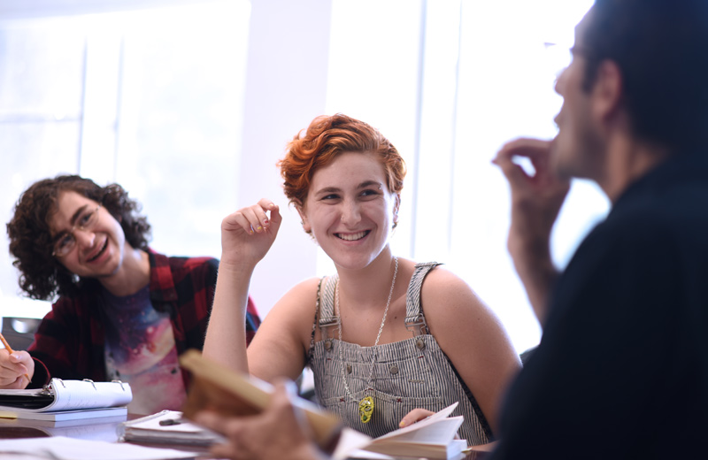 group of students laughing together around work table